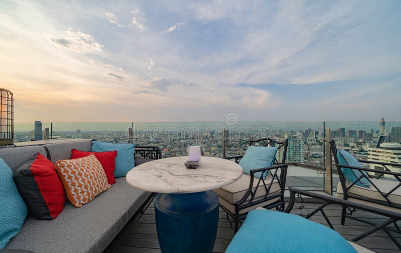 Un ristorante o una terrazza di bar con tavola sul tetto dell'hotel, un edificio ad alta ascesa con vista in città immagini stock