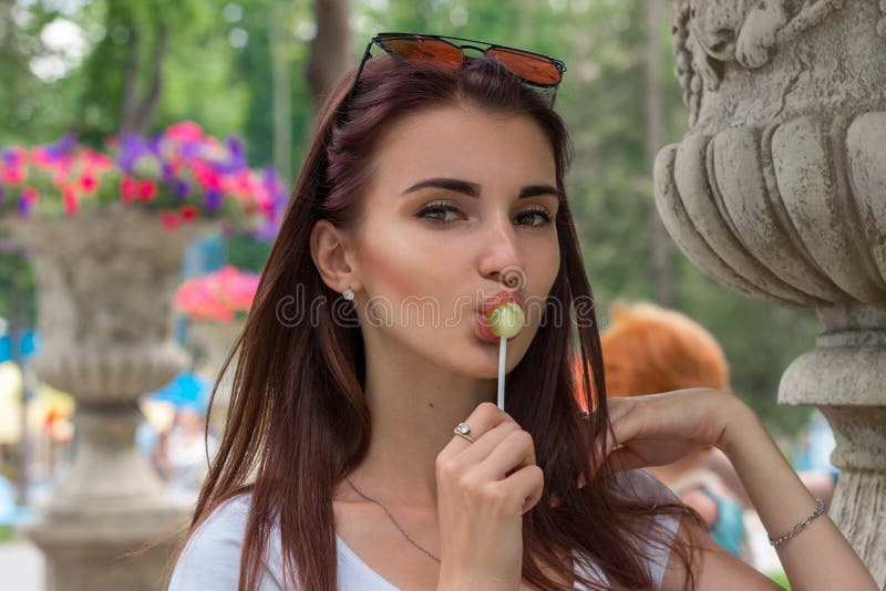 Un ritratto del primo piano di giovane donna sessuale con la lecca-lecca fotografia stock Un ritratto del primo piano di giovane donna sessuale con la lecca-lecca fotografia stock