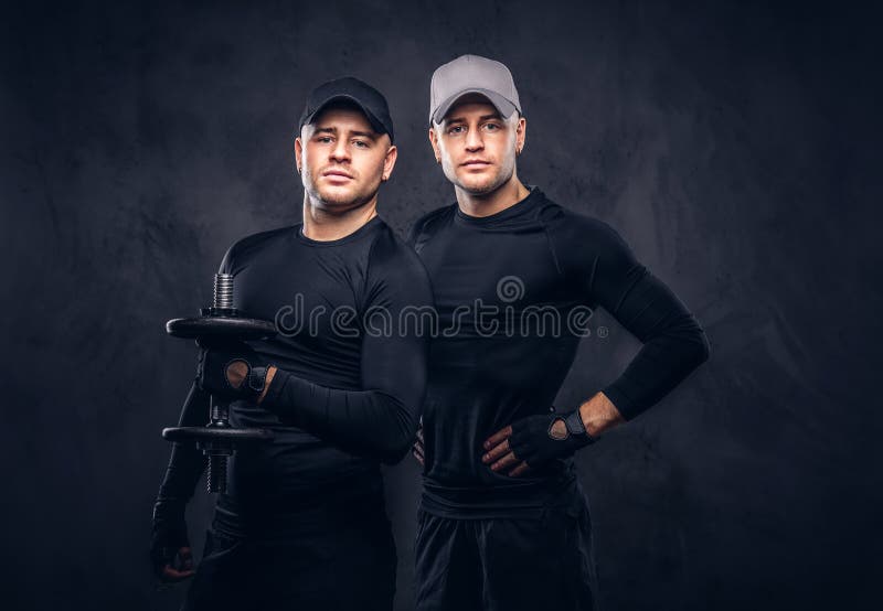 Un ritratto di giovane maschio bello due si è vestito in uno sportswea nero immagini stock libere da diritti Un ritratto di giovane maschio bello due si è vestito in uno sportswea nero immagini stock libere da diritti