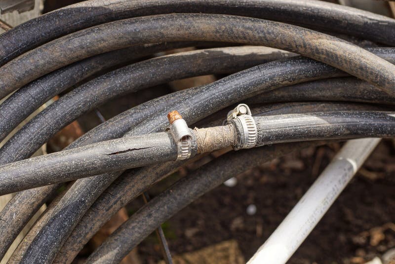 Un rotolo di un vecchio tubo di plastica strappato con una crepa fotografia stock