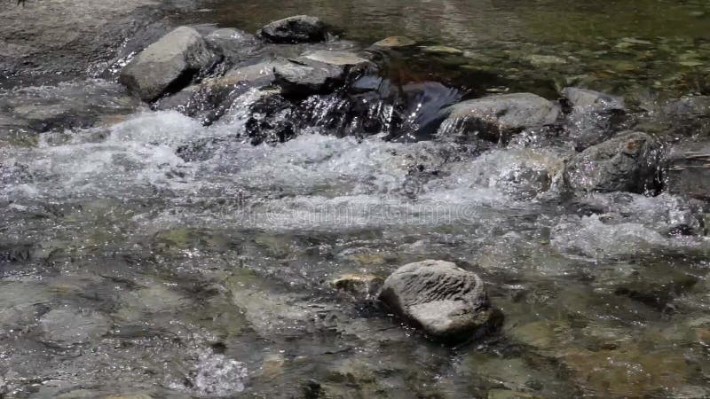 Un río de la montaña con la parte inferior de piedra