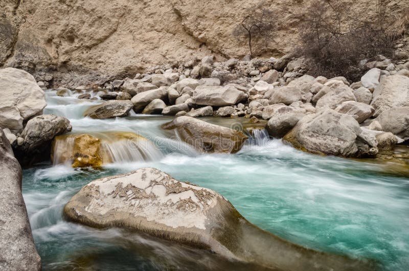 Un río del agua dulce entre las rocas La aguamarina fresca ayuna flujo en las piedras Un río del bosque con la agua fría limpia f fotografía de archivo libre de regalías Un río del agua dulce entre las rocas La aguamarina fresca ayuna flujo en las piedras Un río del bosque con la agua fría limpia f fotografía de archivo libre de regalías
