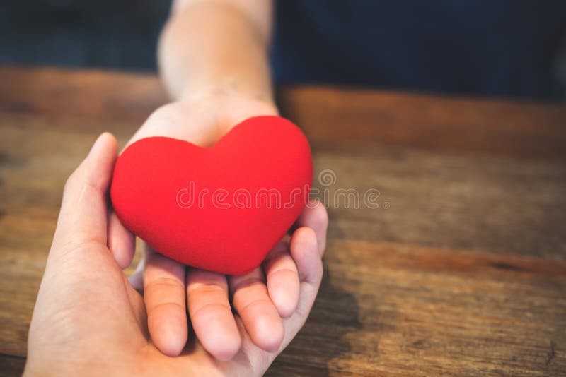Un ` s delle coppie dell'amante passa la tenuta del segno rosso del cuore insieme fotografie stock libere da diritti