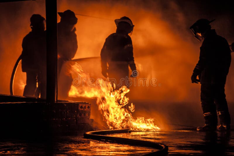Un sapeur-pompier entouré par des flammes image stock Un sapeur-pompier entouré par des flammes image stock