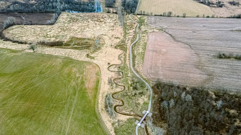 Un sentiero segue un flusso in primavera immagini stock libere da diritti