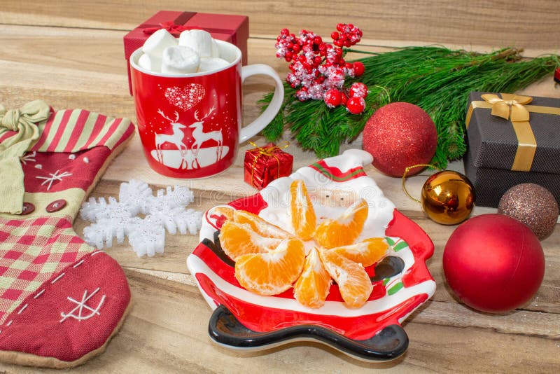 Un sistema de decoraciones de la Navidad - una placa en la forma de Papá Noel con las mandarinas, un calcetín para los regalos, u fotografía de archivo Un sistema de decoraciones de la Navidad - una placa en la forma de Papá Noel con las mandarinas, un calcetín para los regalos, u fotografía de archivo