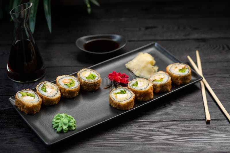 un sistema de rollos con queso e hierbas en una placa negra en un fondo de madera negro fotografía de archivo libre de regalías un sistema de rollos con queso e hierbas en una placa negra en un fondo de madera negro fotografía de archivo libre de regalías