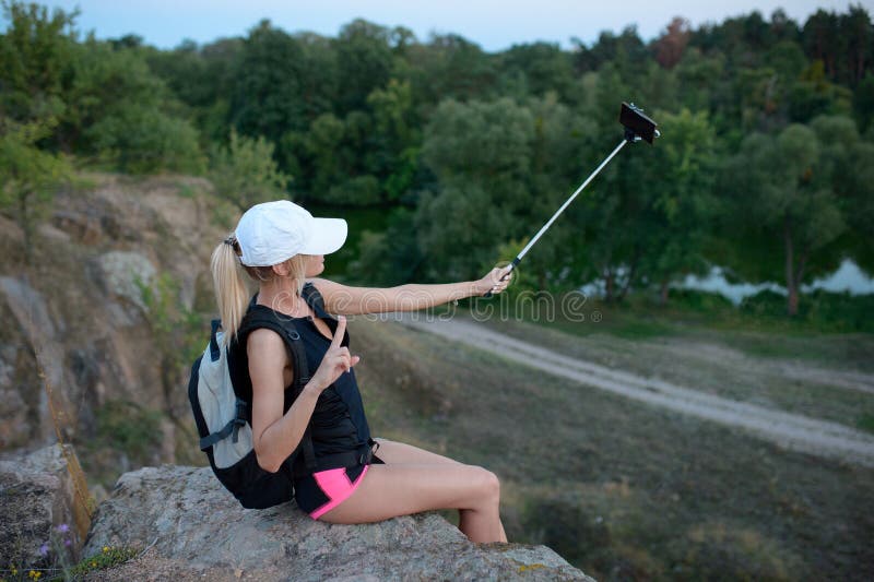 Un smartphone d'utilisation de randonneur de jeune femme dehors photos stock Un smartphone d'utilisation de randonneur de jeune femme dehors photos stock