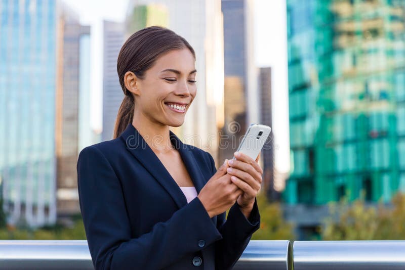 Un SMS di una donna che usa un'app su smartphone nel distretto commerciale della città Giovane donna d'affari che usa uno smartph