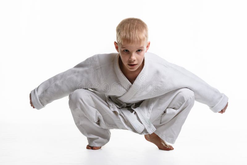 Un student la arte marțiale îmbrăcat într-un kimono, cântă un squat royalty free stock photos