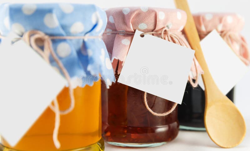 Un tarro con la miel, la mora y la flor atascan en un fondo blanco imagenes de archivo Un tarro con la miel, la mora y la flor atascan en un fondo blanco imagenes de archivo