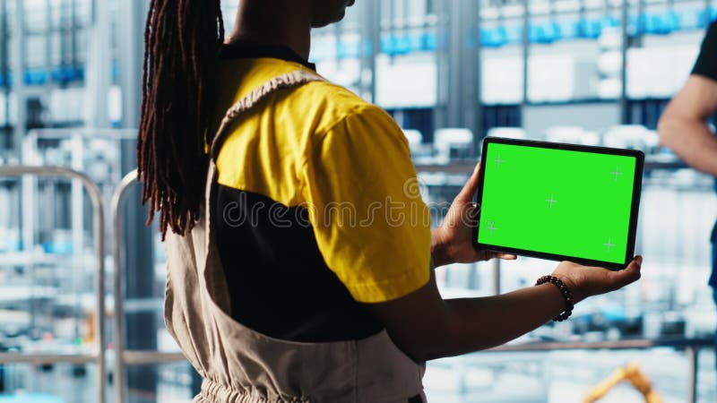 Un technicien d'usine intelligent gère les bras robotisés à l'aide d'un ordinateur portable mockup banque de vidéos