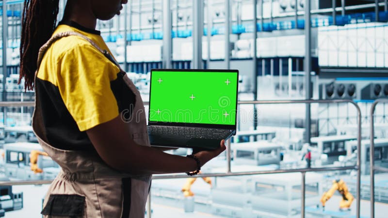 Un technicien d'usine intelligent gère les bras robotisés à l'aide d'un ordinateur portable mockup clips vidéos
