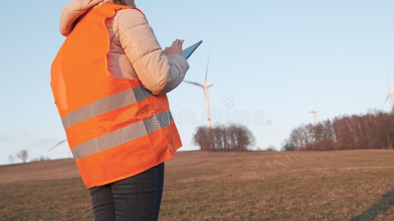 Un technicien en éoliennes contrôle l'exploitation des éoliennes le soir. production d'électricité verte banque de vidéos