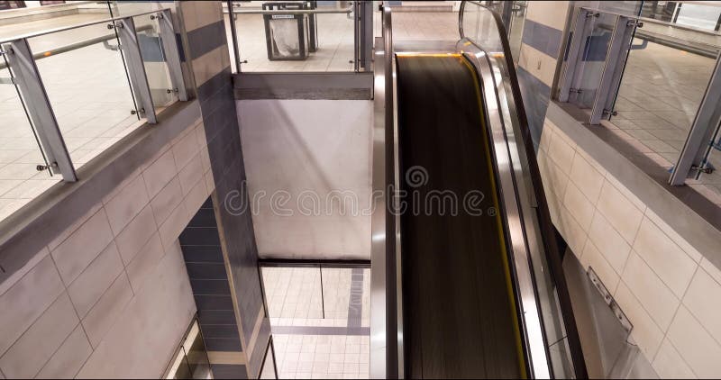 Un timelapse del viajeros que usan una escalera móvil en una línea estación de metro de Canadá en Vancouver, A.C.