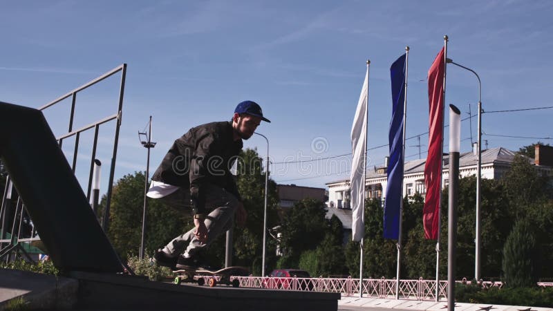Un tipo guapo saltando en una patineta. joven disfrutando de la ciudad moviéndose en patineta. ocio urbano en buen estado almacen de video