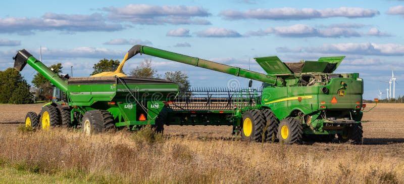 Un tractor John Deere con lúpulo de grano unido que se llena de soja