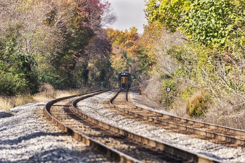 A train Train disappearing into the distance in a rural autumn landscape. Selective focus was used on this image. A train Train disappearing into the distance in a rural autumn landscape. Selective focus was used on this image.