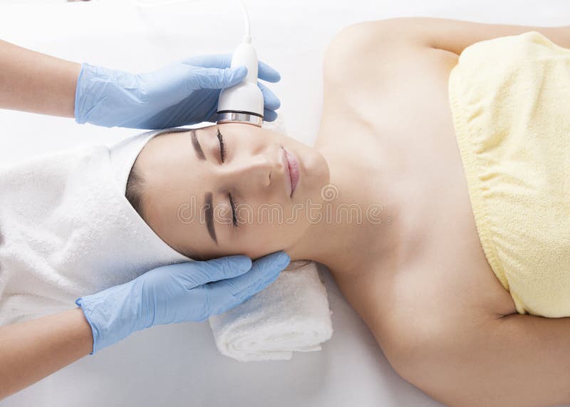 A beautiful young woman lies peacefully during a cosmetic procedure. The beautician thoroughly rejuvenates the patient. A beautiful young woman lies peacefully during a cosmetic procedure. The beautician thoroughly rejuvenates the patient.