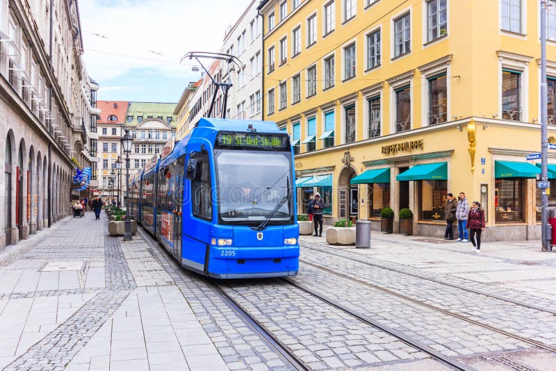 Un tram elettrico che passa con la bella costruzione intorno al teatro nazionale di Monaco di Baviera (Residenztheater) fotografia stock