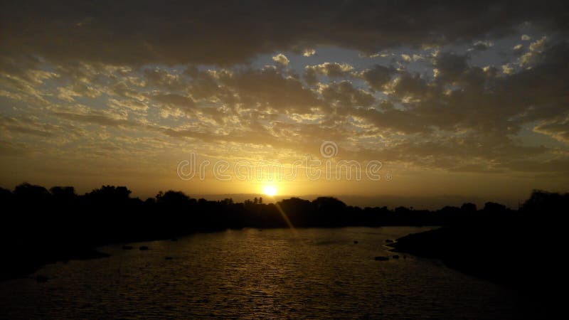 Un tramonto perfetto su River and Bridge fotografia stock Un tramonto perfetto su River and Bridge fotografia stock