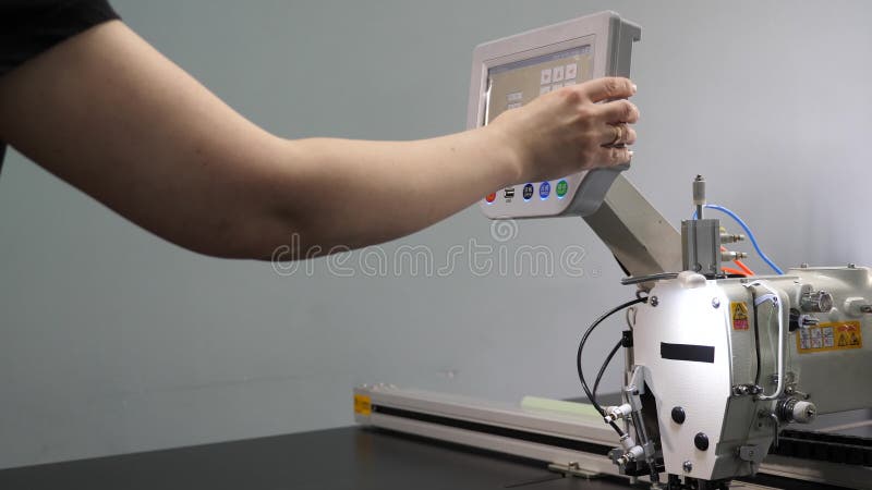 Un travailleur programme une machine à coudre avec un CNC à l'aide d'un ordinateur tablette L'opérateur configure la machine cnc banque de vidéos