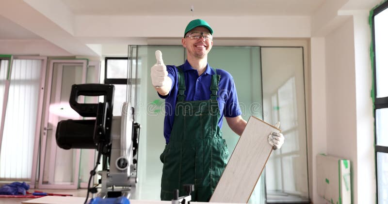 Un travailleur souriant montre un pouce debout près d'une machine à scier banque de vidéos