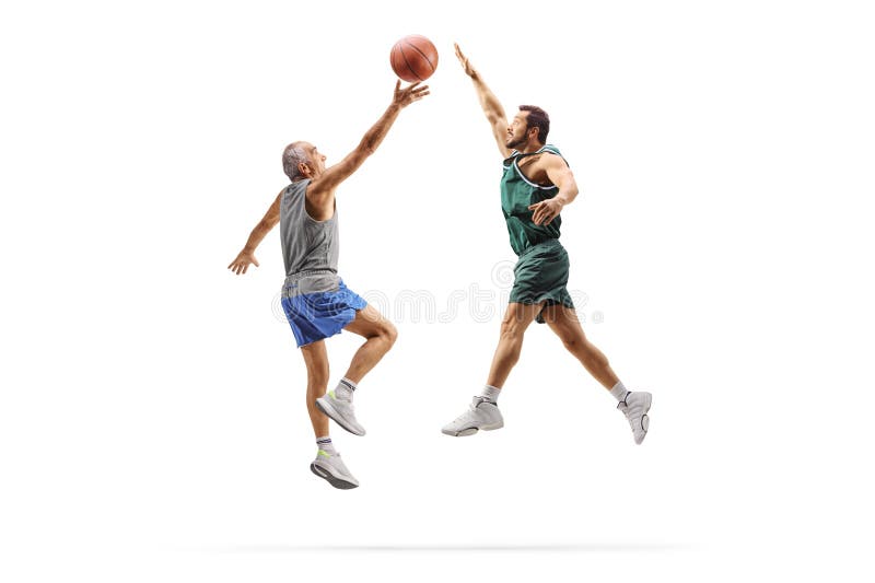 Un uomo anziano che gioca a basket con un atleta più giovane fotografia stock libera da diritti