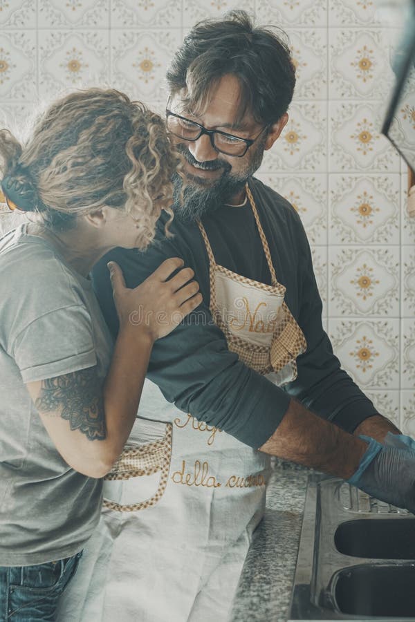 Un uomo che aiuta la moglie a lavare i piatti in cucina. donna apprezza l'aiuto del marito nelle casalinghe fotografie stock libere da diritti