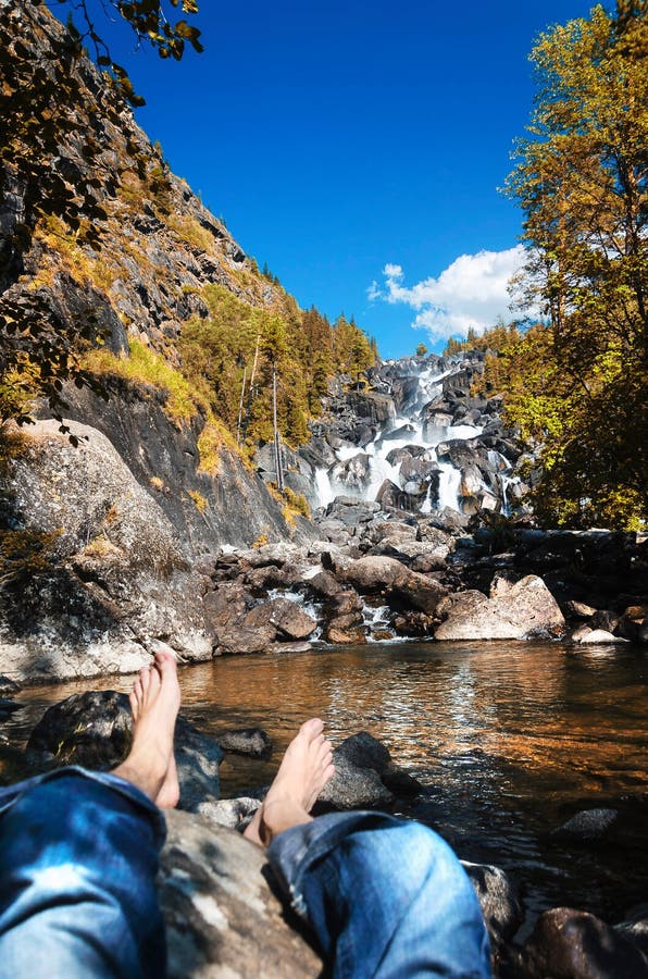 Un uomo che riposa alla cascata in montagne di Altai, Repubblica di Altai, Siberia, Russia di Uchar immagini stock Un uomo che riposa alla cascata in montagne di Altai, Repubblica di Altai, Siberia, Russia di Uchar immagini stock