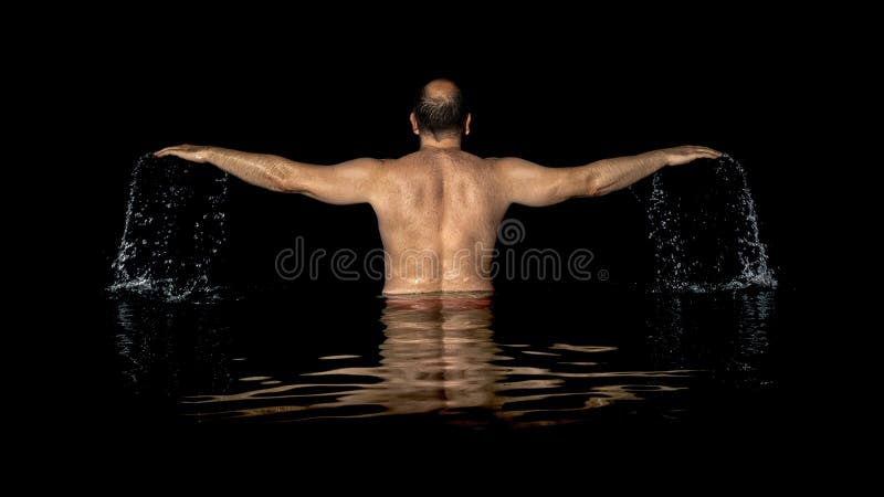 Un uomo che sta dentro l'acqua e le diffusioni il suo armi fotografie stock Un uomo che sta dentro l'acqua e le diffusioni il suo armi fotografie stock