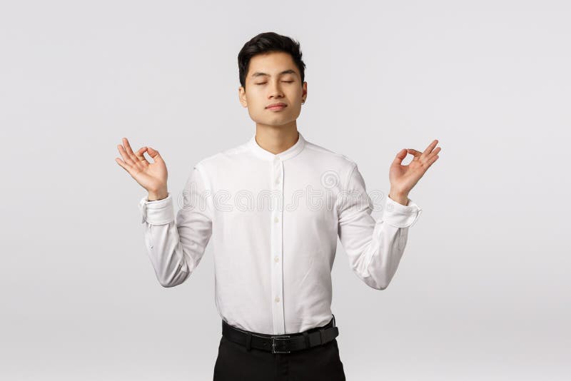 Un uomo d'affari asiatico pacifico e determinato, calmati, liberati stress, occhi chiusi e meditando in ufficio immagini stock libere da diritti Un uomo d'affari asiatico pacifico e determinato, calmati, liberati stress, occhi chiusi e meditando in ufficio immagini stock libere da diritti