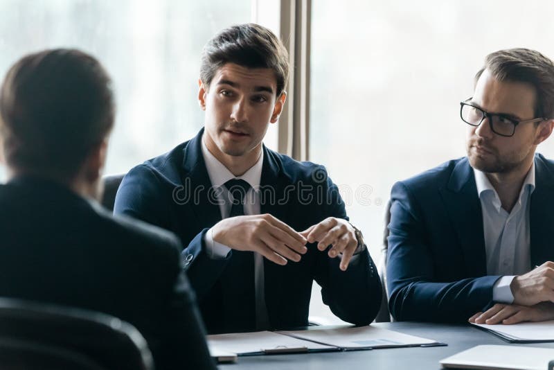 Un uomo d'affari fidato discute un progetto seduto al tavolo del consiglio di amministrazione