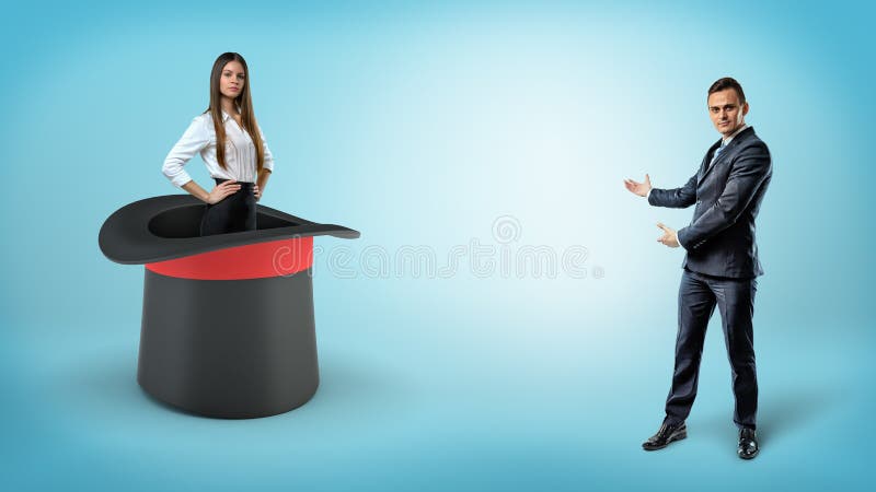 Un uomo d'affari mostra una donna di affari sicura di sé che sta dentro un cappello gigante degli illusionisti su un fondo blu