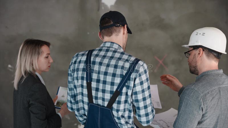 Un uomo e una donna con cappelli duri condividono una stanza ad un evento di ingegneria video d archivio
