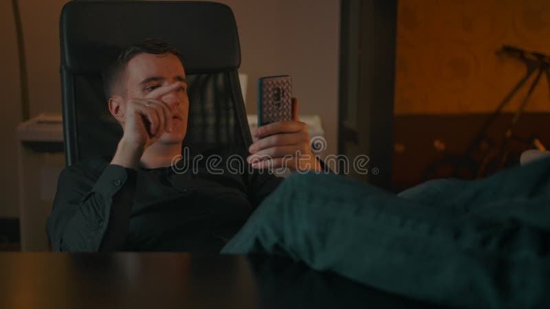 Un uomo fa una videochiamata attraverso uno smartphone in un interno domestico