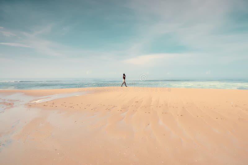 Un uomo solo che cammina sulla spiaggia immagine stock libera da diritti Un uomo solo che cammina sulla spiaggia immagine stock libera da diritti