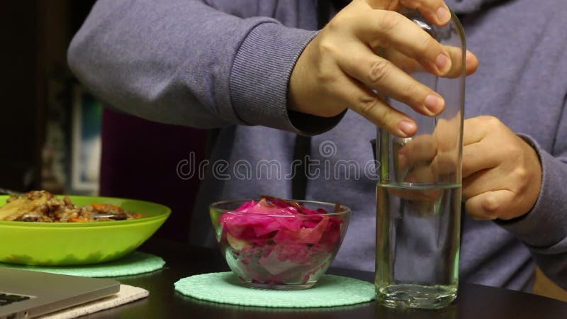 Un Uomo Sta Cenando Mentre Guarda Un Film Su Un Portatile. Versare Un  Bicchiere Di Vodka E Di Snack. Chiusura a Scatto Stock Footage - Video di  alimento, casa: 257623686