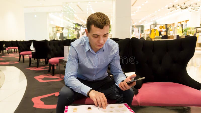 Un uomo sta guardando un menù in un bar in un centro commerciale.