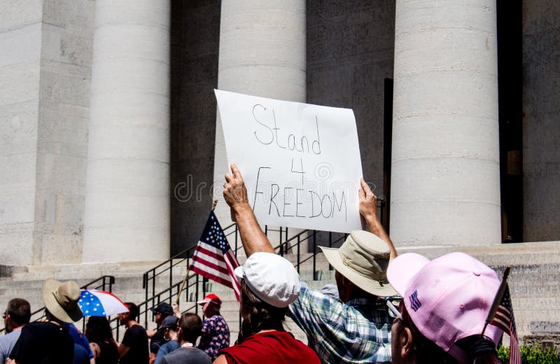 A man holds a sign that reads `Stand 4 Freedom`in a crowd of protestors. Taken at a conservative rally supporting Donald Trump, and against mask mandates due to COVID-19. July 18th 2020. Downtown Columbus Ohio. Stand for America Rally. A man holds a sign that reads `Stand 4 Freedom`in a crowd of protestors. Taken at a conservative rally supporting Donald Trump, and against mask mandates due to COVID-19. July 18th 2020. Downtown Columbus Ohio. Stand for America Rally.