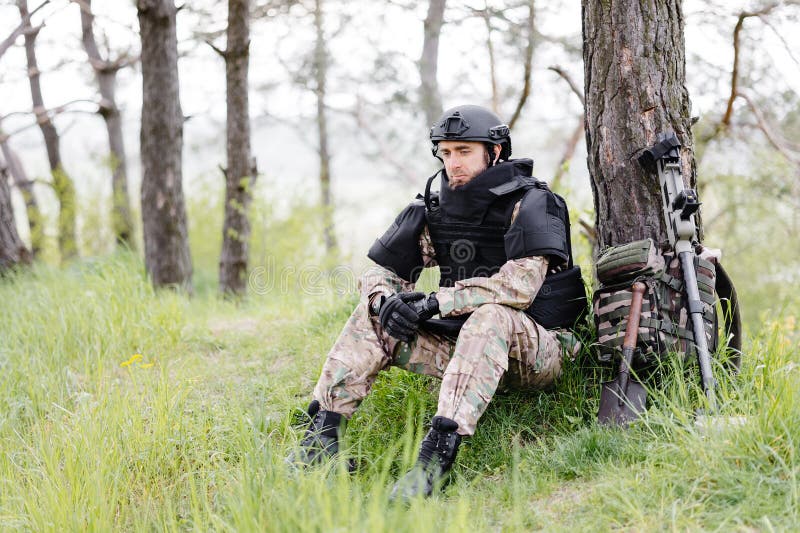 Un Uomo in Uniforme Militare E Un Giubbotto Antiproiettile Lavora Nella  Foresta Per Deminare Il Territorio. Un Uomo Mette Su Un Ca Immagine Stock -  Immagine di munito, caucasico: 277401063