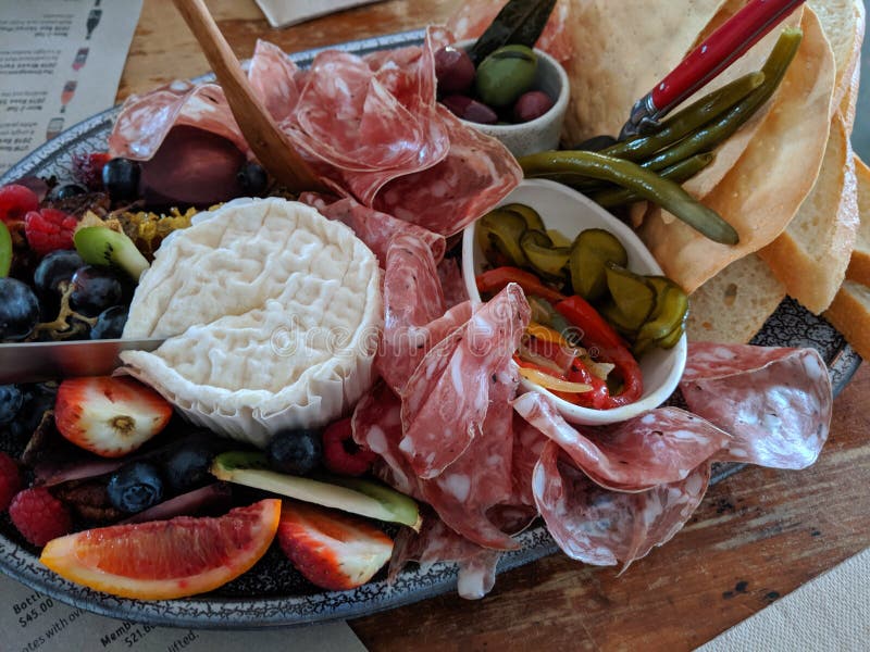Un vassoio delle carni, dei formaggi e dei frutti immagine stock Un vassoio delle carni, dei formaggi e dei frutti immagine stock