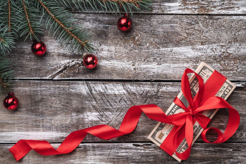 Un vecchio fondo di legno di Natale, un albero di abete con le bagattelle, soldi abbelliti con l'allentamento rosso fotografie stock libere da diritti Un vecchio fondo di legno di Natale, un albero di abete con le bagattelle, soldi abbelliti con l'allentamento rosso fotografie stock libere da diritti