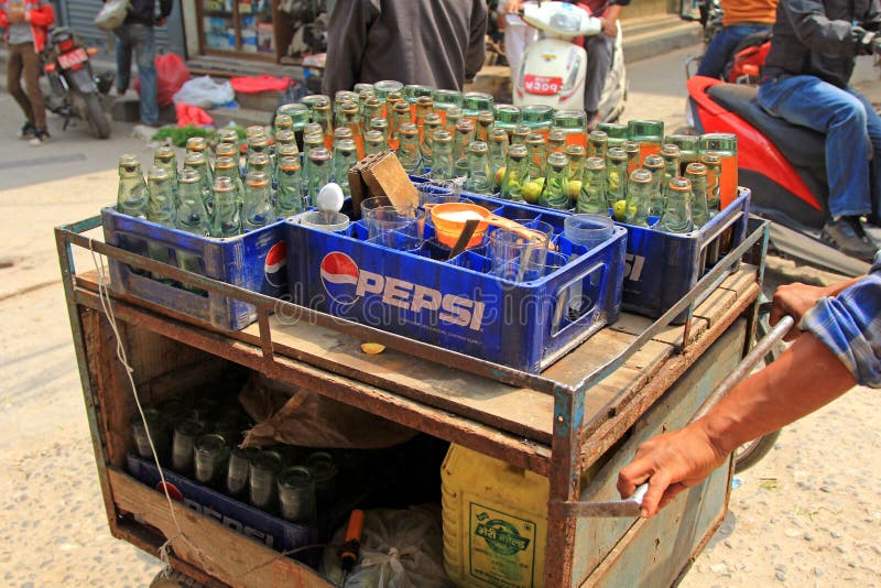 PATAN, NEPAL - APRIL 2014 : A street vendor selling Fresh Lime Soda in Patan, Nepal on 13 April 2014. Fresh lime soda is a common beverage in Nepal which consists of lime juice, sugar and club soda or other carbonated drink. PATAN, NEPAL - APRIL 2014 : A street vendor selling Fresh Lime Soda in Patan, Nepal on 13 April 2014. Fresh lime soda is a common beverage in Nepal which consists of lime juice, sugar and club soda or other carbonated drink.