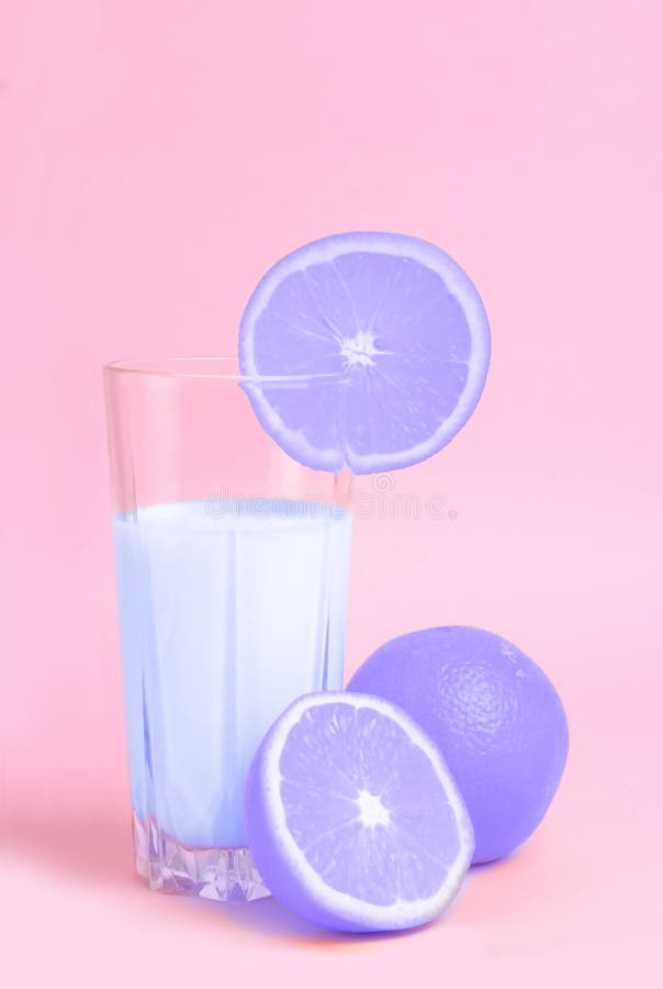 Un verre avec le jus d'orange avec les oranges de coupe sur un backgro rose photo libre de droits Un verre avec le jus d'orange avec les oranges de coupe sur un backgro rose photo libre de droits