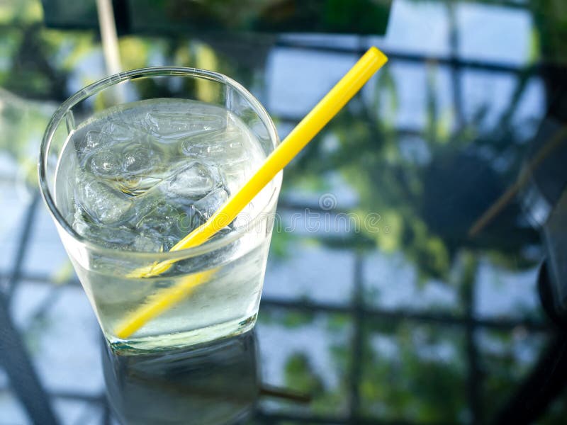 Un verre d'eau potable froide avec la paille jaune photographie stock libre de droits Un verre d'eau potable froide avec la paille jaune photographie stock libre de droits