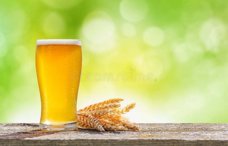Un verre de bière froide placé sur une table avec un fond de bokeh extérieur doux images stock