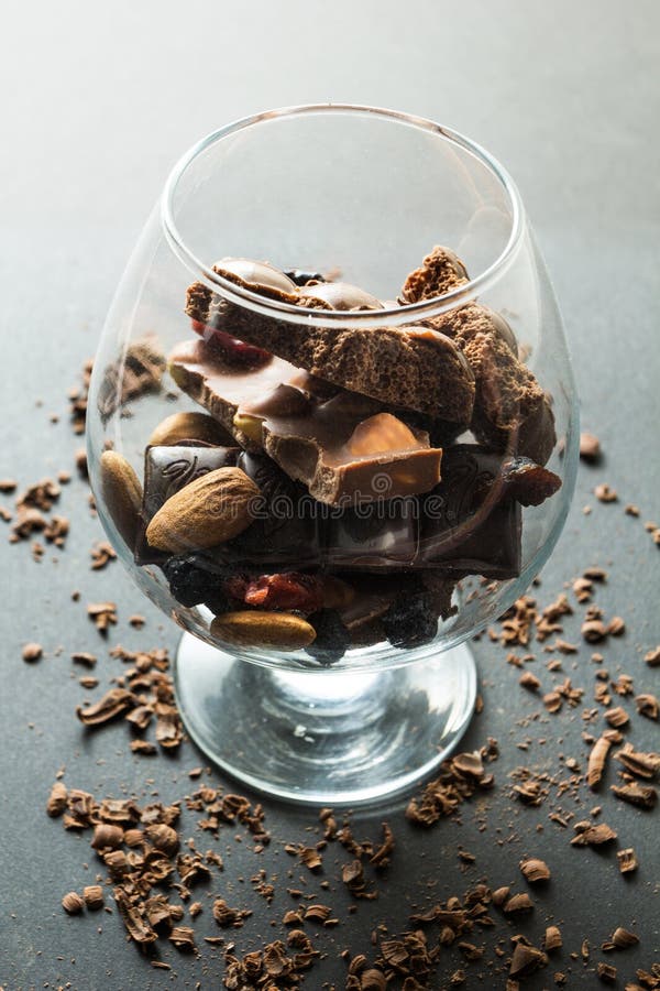 Un verre de chocolat sur un fond noir, miettes de chocolat image stock Un verre de chocolat sur un fond noir, miettes de chocolat image stock