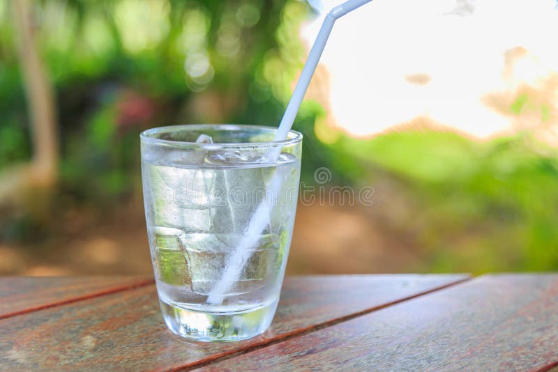 Un vetro di acqua fredda su una tavola di legno fotografie stock Un vetro di acqua fredda su una tavola di legno fotografie stock