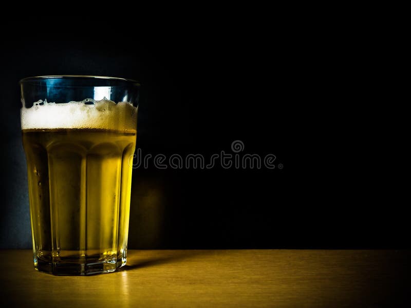 Un vidrio de cerveza en fondo negro imagen de archivo Un vidrio de cerveza en fondo negro imagen de archivo